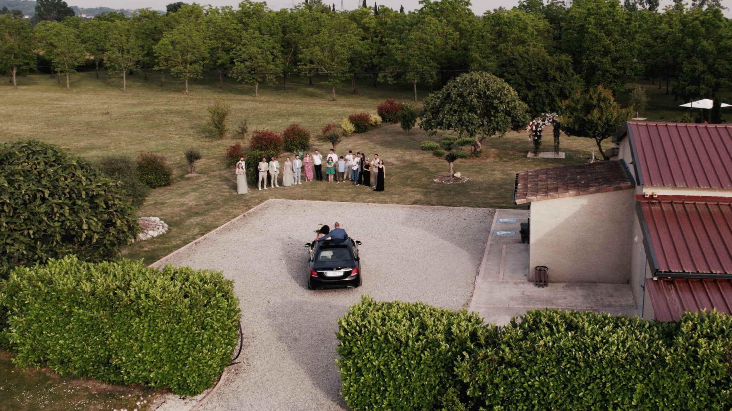 Départ des mariés en cabriolet salués par leurs invités au domaine-des-oliviers près de Toulouse
