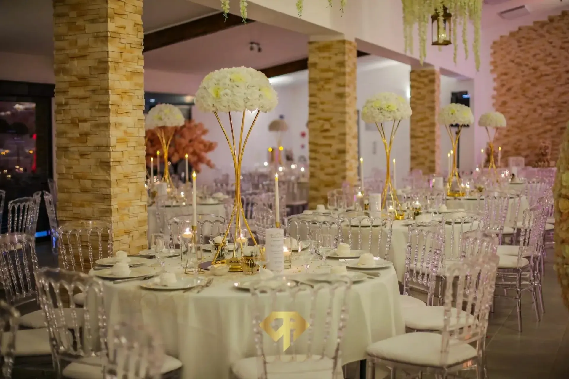Salle de réception mariage chic au domaine-des-oliviers à Toulouse, tables blanches, fleurs et bougies élégantes